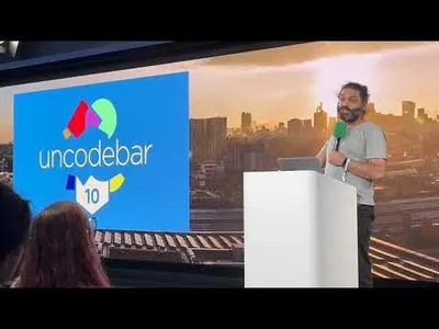 Louie Christie stading at a microphone and lecturn. A screen behind him says 'Uncodebar 10'